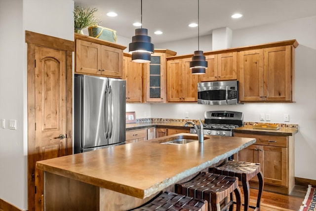 kitchen with glass insert cabinets, recessed lighting, stainless steel appliances, a kitchen bar, and decorative light fixtures