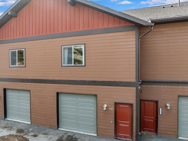 exterior space featuring an attached garage and roof with shingles