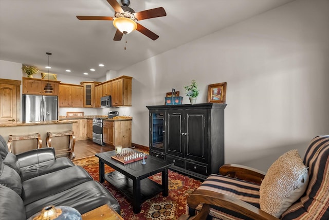 living room with a ceiling fan, recessed lighting, dark wood finished floors, and baseboards