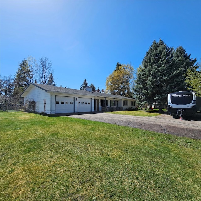 single story home with an attached garage, driveway, fence, and a front yard