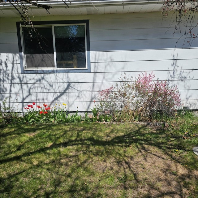 view of side of home with a yard
