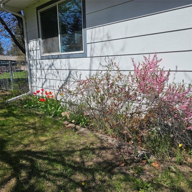 view of home's exterior with a lawn and fence
