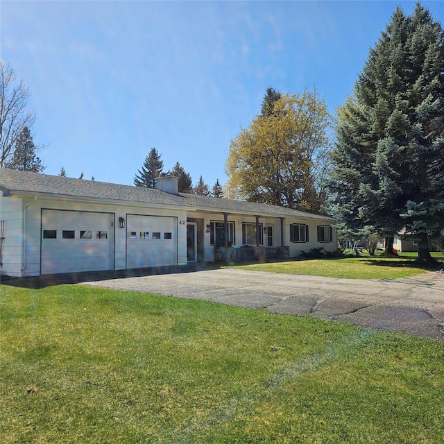ranch-style home featuring a front lawn, aphalt driveway, and a garage