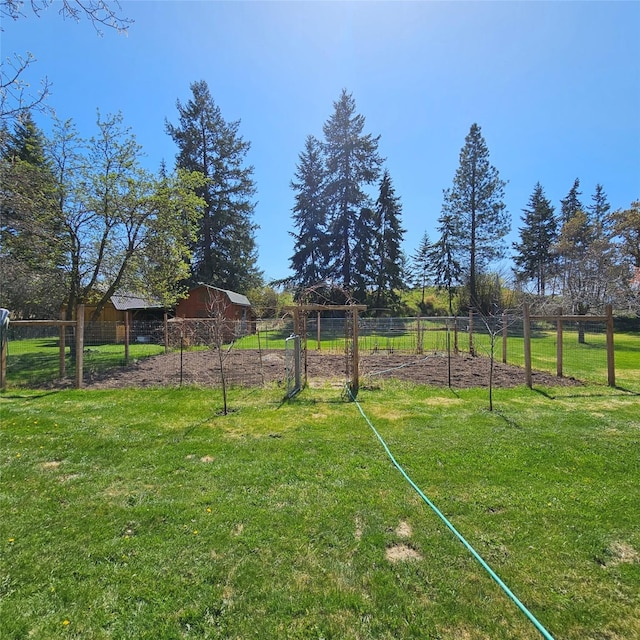 view of yard with fence, an outbuilding, and a barn