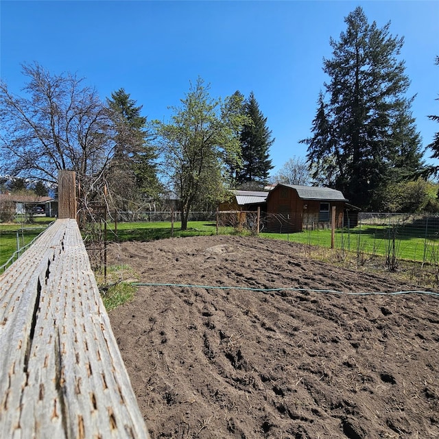 view of yard with fence, an outbuilding, and a barn