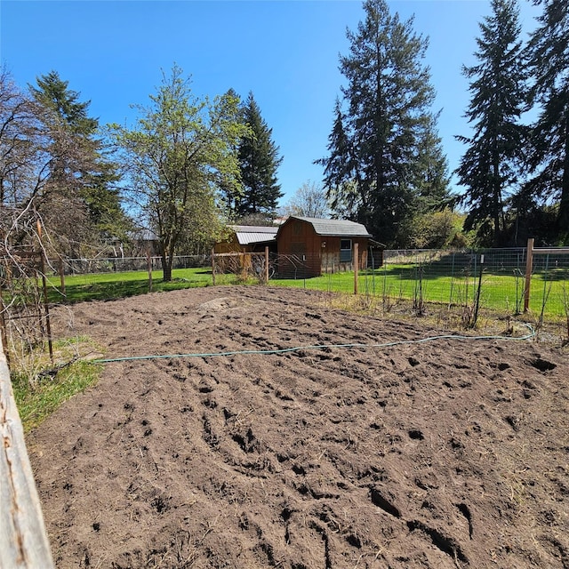 view of yard with fence, a barn, and an outbuilding