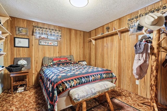 carpeted bedroom featuring wooden walls and a textured ceiling