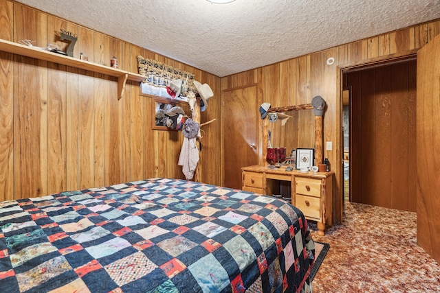 bedroom featuring a textured ceiling, wooden walls, and carpet floors