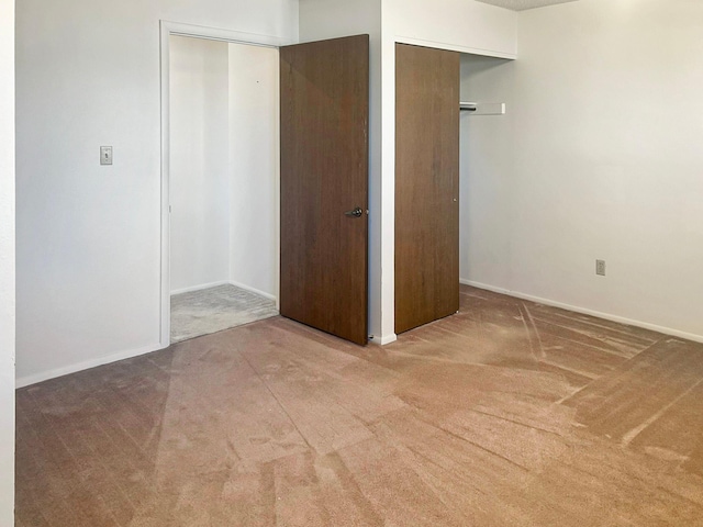 unfurnished bedroom featuring carpet floors and baseboards