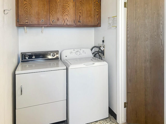 clothes washing area with cabinet space and washer and dryer