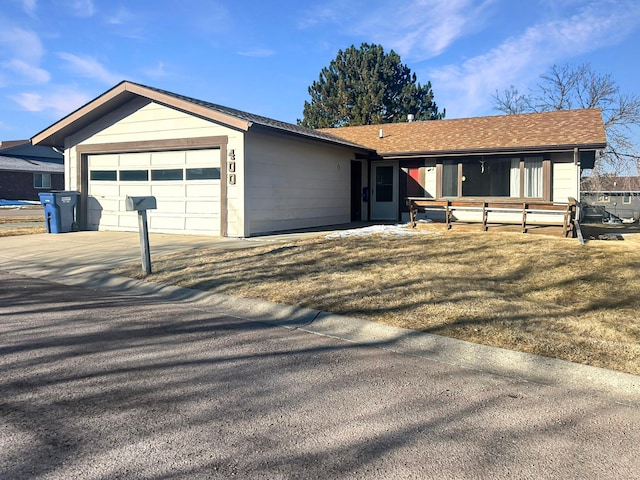 ranch-style house with a garage, driveway, and a shingled roof