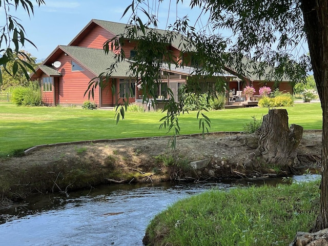 exterior space featuring a lawn and a water view