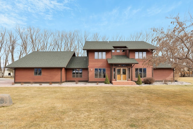 view of front of house with a front lawn and roof with shingles