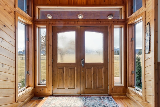 297 Christofferson Ln, Corvallis, MT 59828 - doorway to outside with wood walls, plenty of natural light, and light wood-style floors