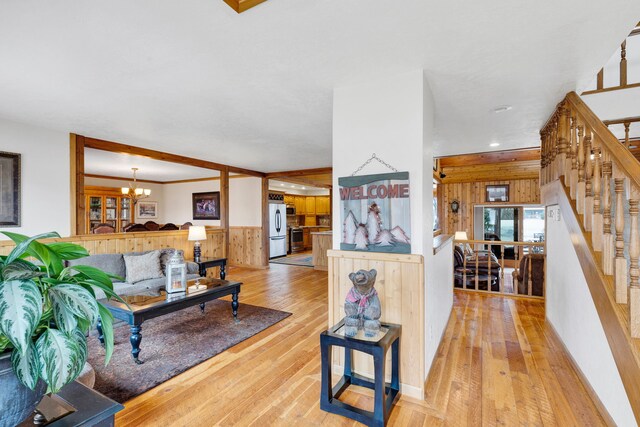 297 Christofferson Ln, Corvallis, MT 59828 - living room featuring a chandelier, light wood-style flooring, a wainscoted wall, stairway, and recessed lighting