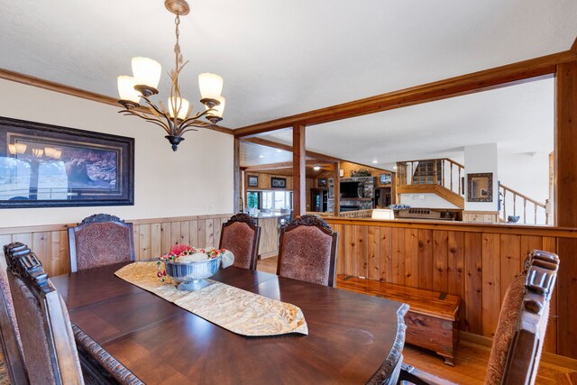 297 Christofferson Ln, Corvallis, MT 59828 - dining space with a chandelier, wainscoting, wood finished floors, and wooden walls