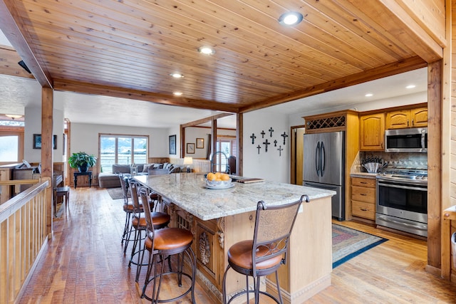 297 Christofferson Ln, Corvallis, MT 59828 - kitchen featuring appliances with stainless steel finishes, light wood-style flooring, wooden ceiling, a center island with sink, and open floor plan