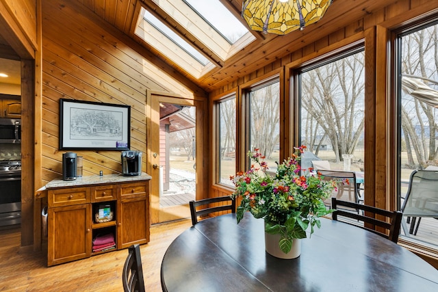 297 Christofferson Ln, Corvallis, MT 59828 - dining area featuring wood walls, a skylight, lofted ceiling, and light wood finished floors