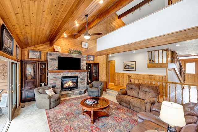 297 Christofferson Ln, Corvallis, MT 59828 - living area with wooden walls, a stone fireplace, ceiling fan, light carpet, and a wainscoted wall