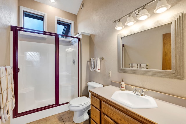 297 Christofferson Ln, Corvallis, MT 59828 - bathroom with a textured wall, a stall shower, tile patterned floors, toilet, and vanity