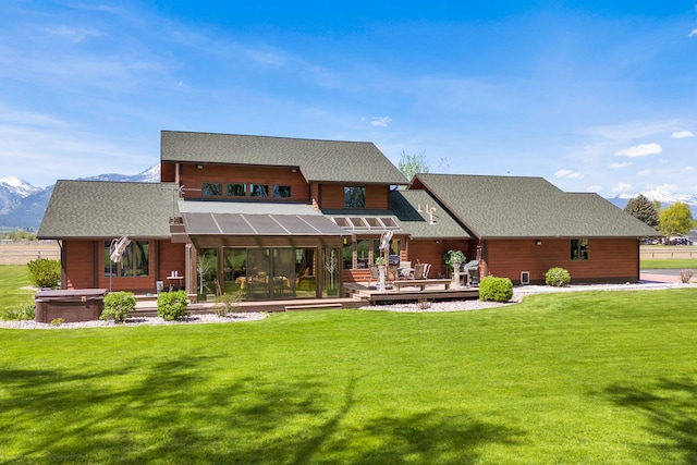 297 Christofferson Ln, Corvallis, MT 59828 - rear view of house featuring a hot tub, a deck with mountain view, and a lawn