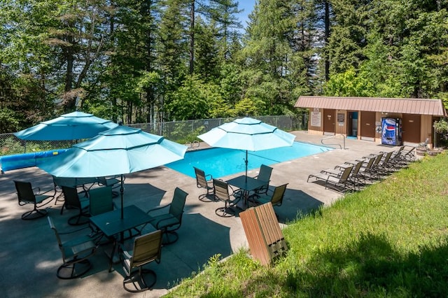 pool with a patio and fence