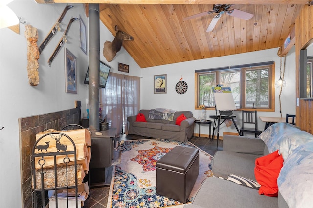 living room featuring wood ceiling, baseboards, vaulted ceiling, a ceiling fan, and a wood stove