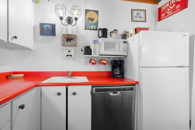 kitchen with white appliances, a sink, and white cabinetry