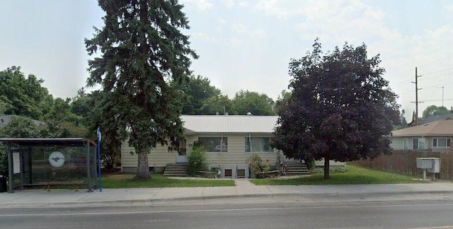 view of front of property featuring a front lawn and fence