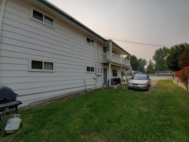 property exterior at dusk with a yard and stairway