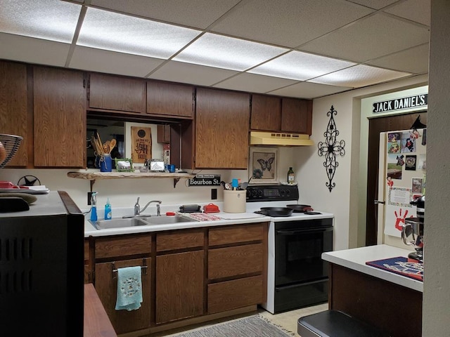 kitchen with electric range, freestanding refrigerator, a paneled ceiling, under cabinet range hood, and a sink