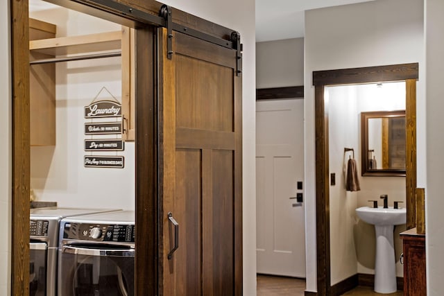 interior space with laundry area, a barn door, a sink, and washing machine and clothes dryer