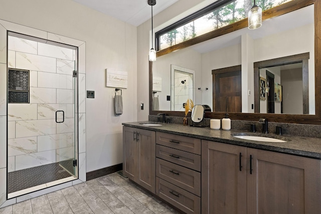 bathroom featuring baseboards, wood finish floors, a sink, and a shower stall