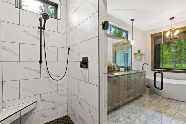 full bathroom with a chandelier, a freestanding tub, a tile shower, and double vanity