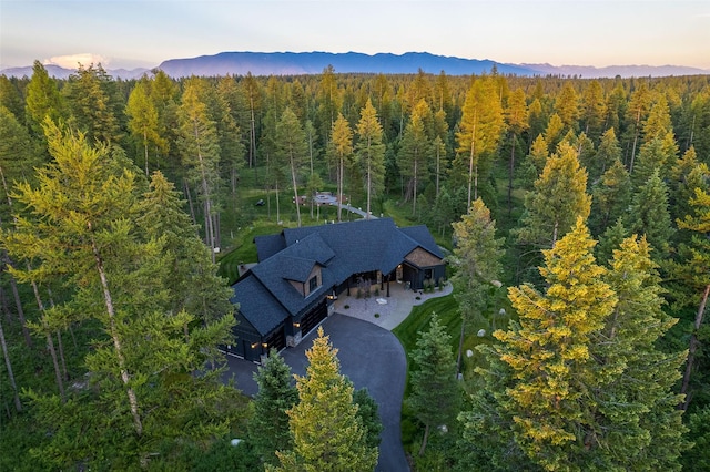 birds eye view of property featuring a wooded view and a mountain view