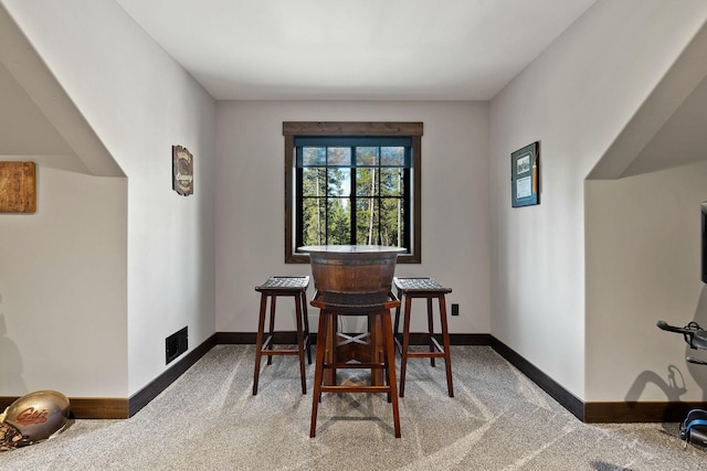 dining space with carpet floors, visible vents, and baseboards