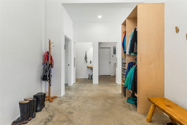 hall featuring concrete floors and baseboards