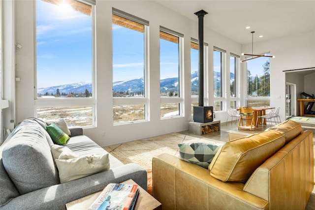 sunroom / solarium featuring a mountain view and a wood stove