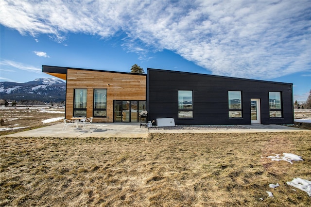 rear view of property with a mountain view and a patio