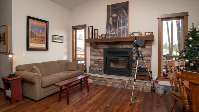 living area with a stone fireplace and wood finished floors