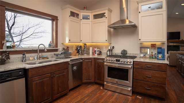 kitchen featuring dark wood-style floors, wall chimney exhaust hood, a sink, and stainless steel appliances