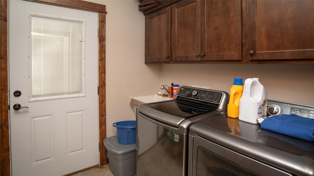 washroom with a sink, cabinet space, and washer and dryer