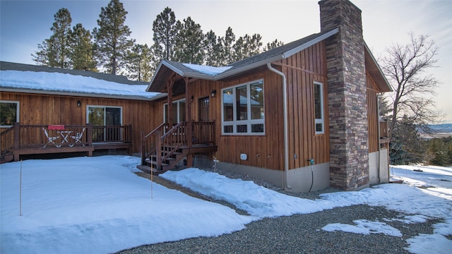 view of front of house with a deck, a chimney, and a garage