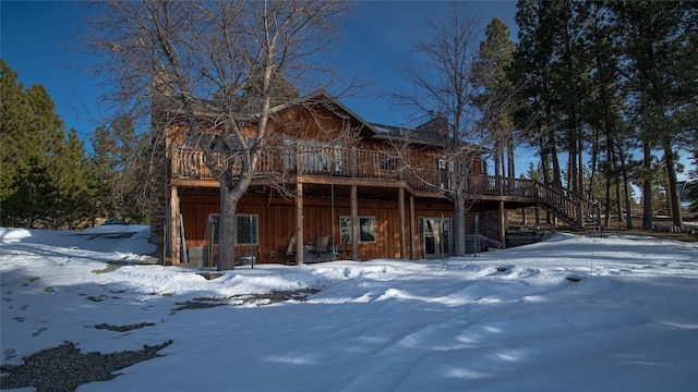 snow covered property featuring stairs