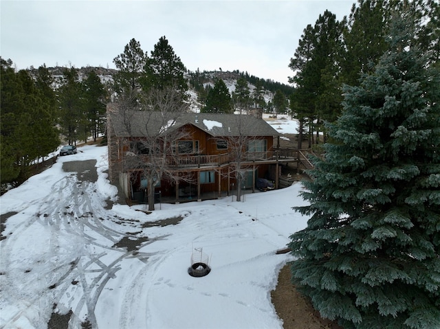 snow covered property featuring stairway and a wooden deck