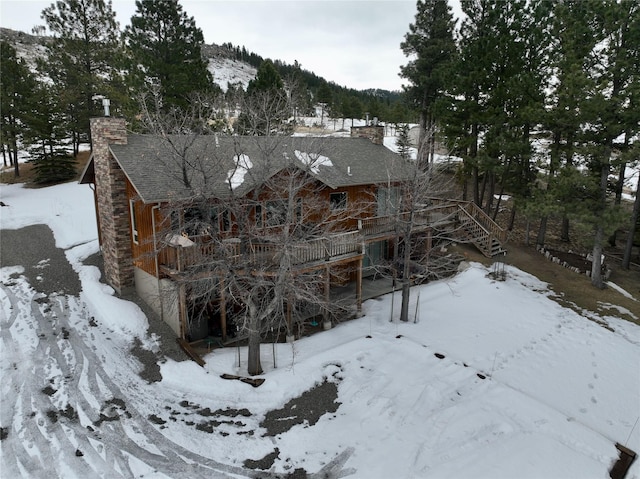 exterior space with a garage, stairway, a chimney, and a mountain view