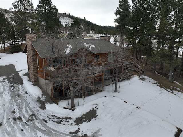 exterior space featuring stairway, a mountain view, a chimney, and a garage