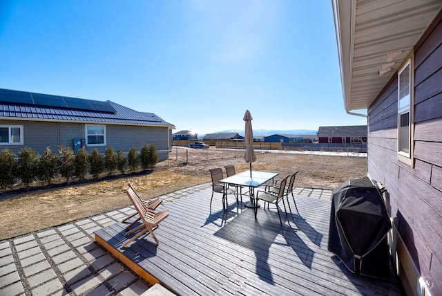 deck featuring fence, a mountain view, grilling area, and outdoor dining space