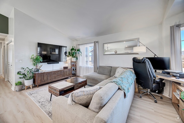 living area with light wood-style floors and vaulted ceiling