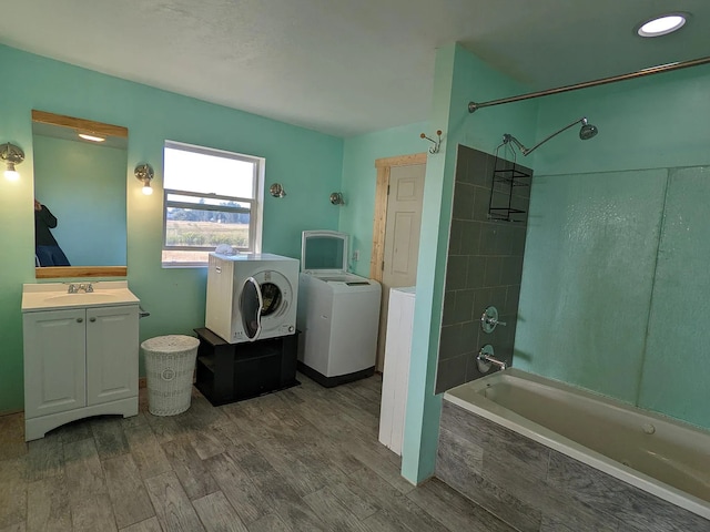 bathroom with vanity, tiled shower / bath, wood finished floors, and washing machine and clothes dryer